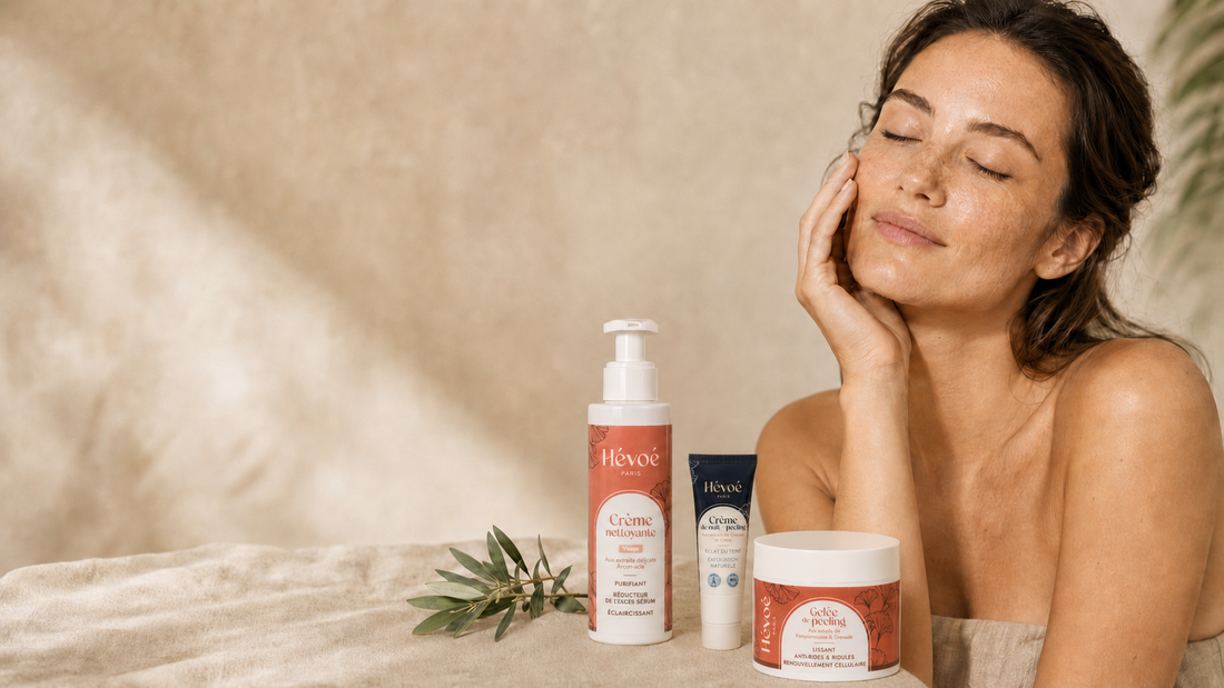 Femme au teint lumineux et uniforme entourée de soins visage naturels Hévoé pour atténuer les taches brunes après l'été