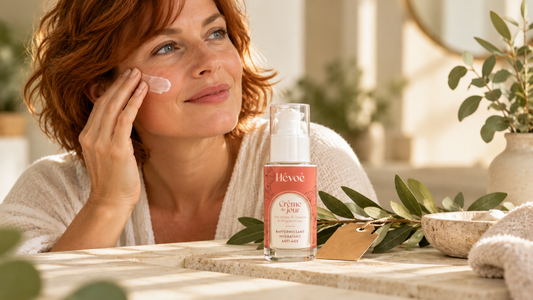 Flacon de soin visage naturel posé à côté d'une étiquette de cosmétique et de feuilles de plantes, lumière douce