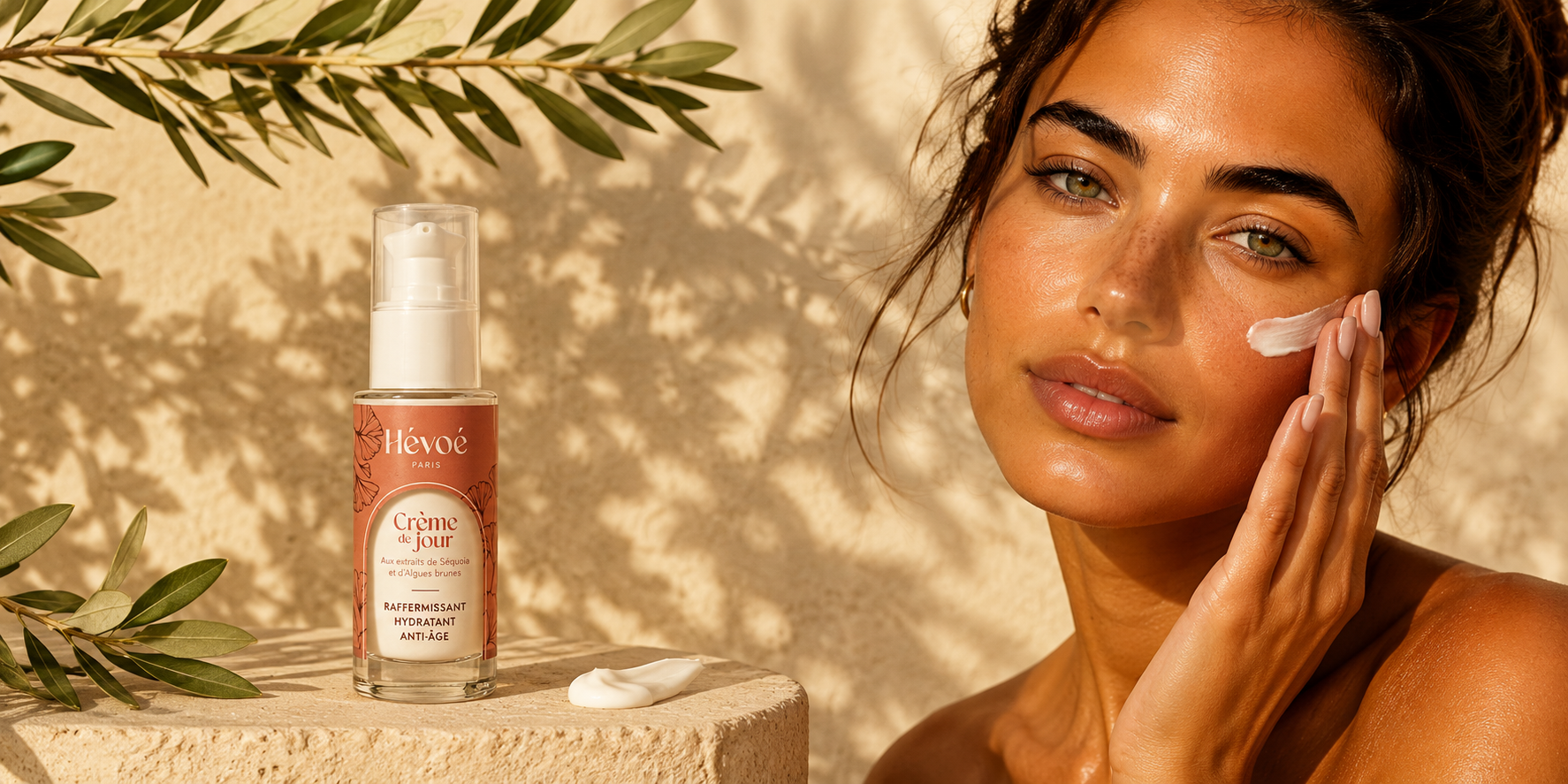 femme en exterieur appliquant la creme de jour hevoe sous un olivier