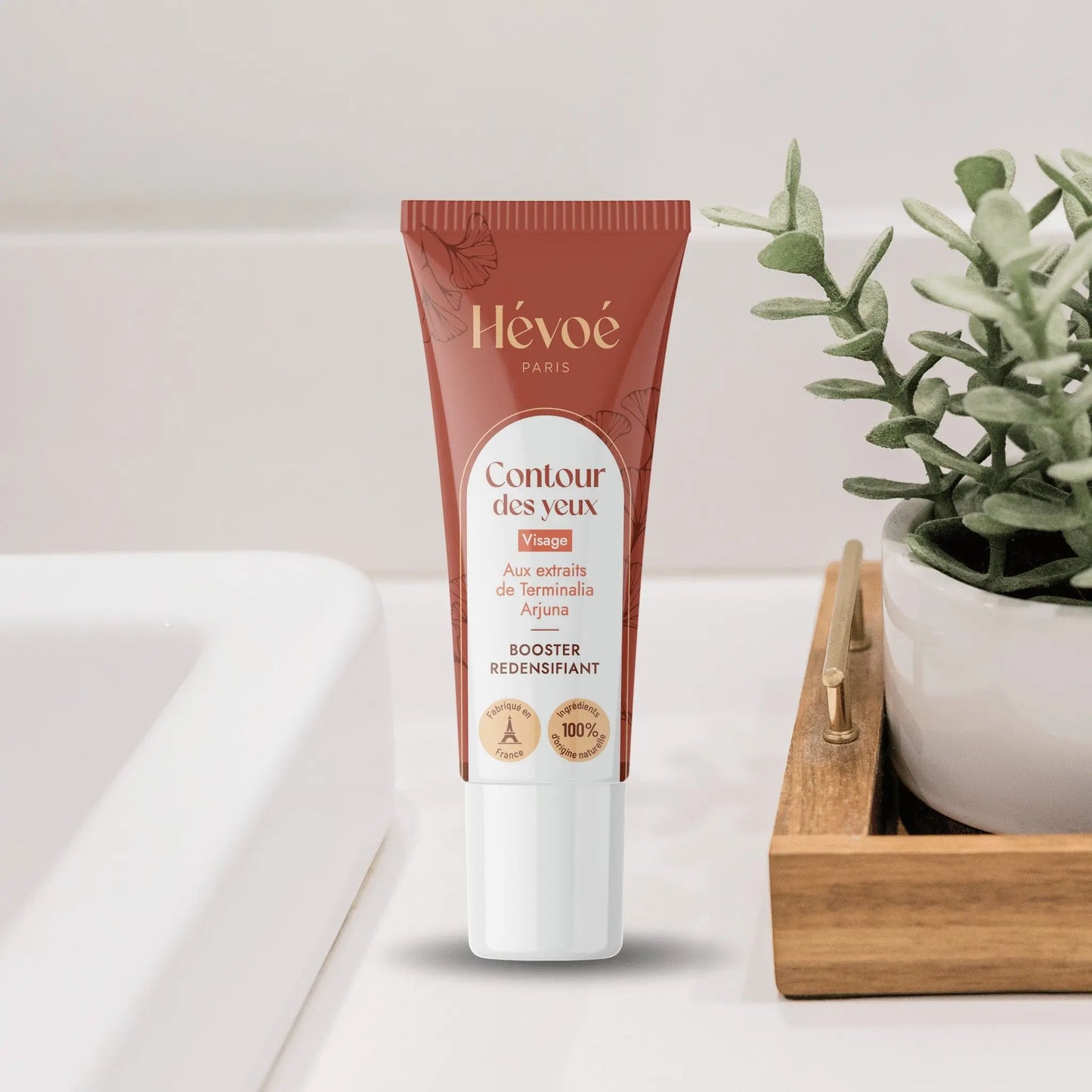 HEVOE Crème Contour des Yeux, tube brun avec feuilles de ginkgo, pour un regard reposé.